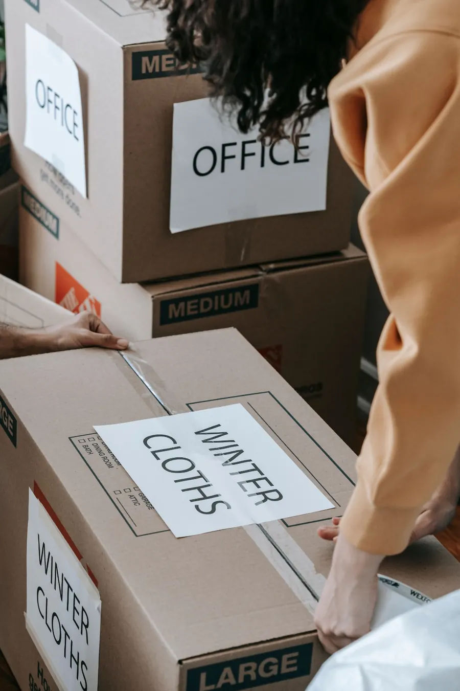 Labeled boxes marked Office and Winter Cloths being taped up